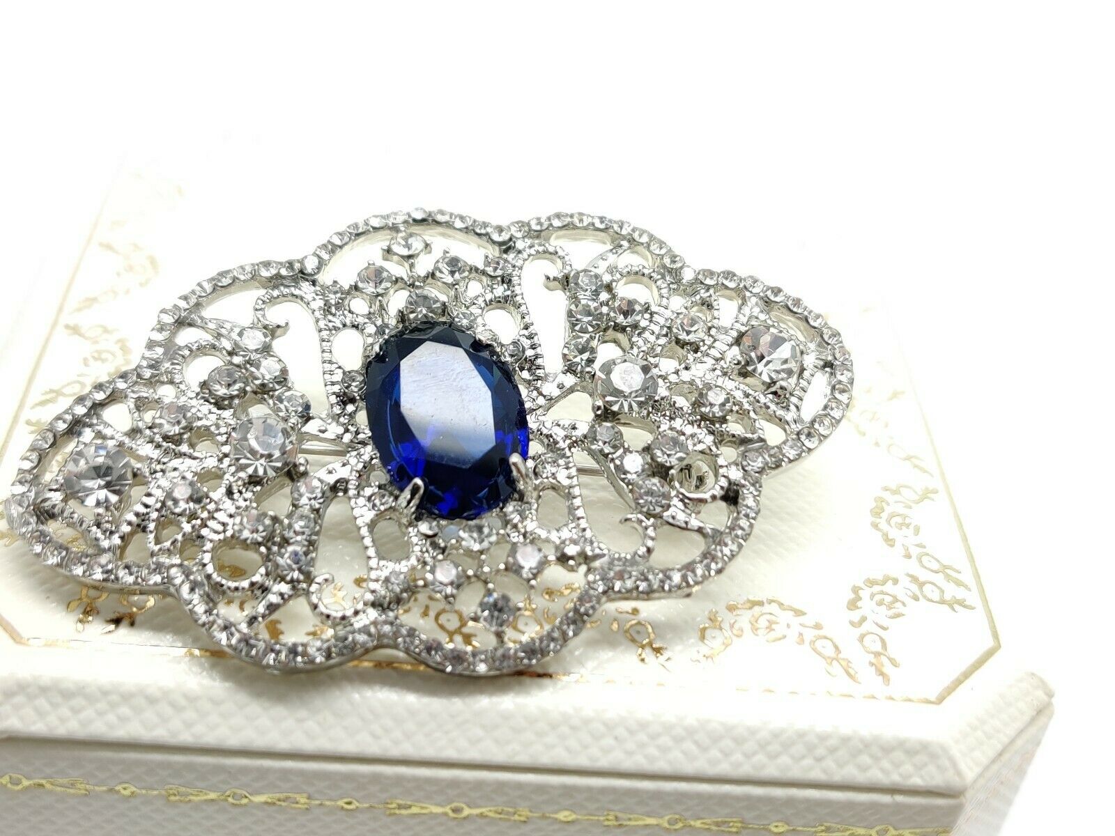 White gold finish blue sapphire and created diamond broach