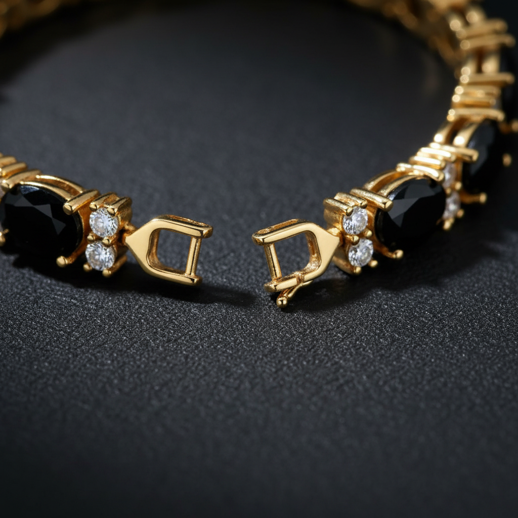Close-up of the gold box clasp and oval black onyx links on a created diamond tennis bracelet