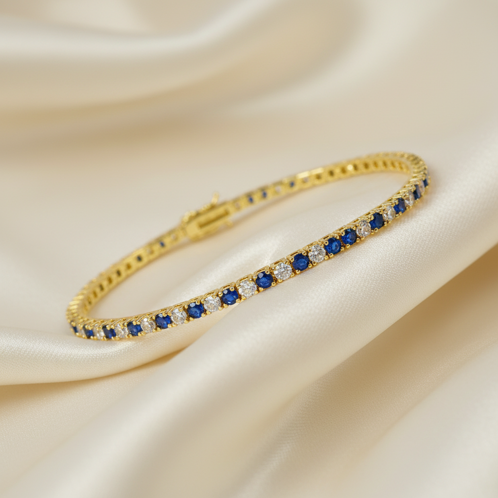 Yellow gold tennis bracelet with round blue sapphires and created diamonds resting on ivory silk