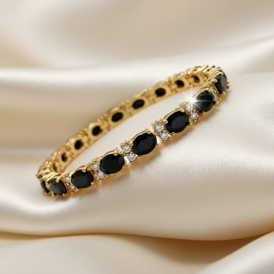 Yellow gold tennis bracelet set with oval black onyx and created diamonds, draped on cream silk